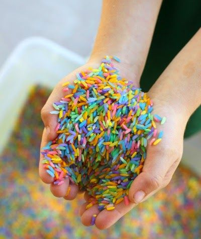 Child holding a handful of colored rice