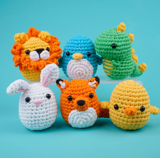 A crochet lion, penguin, dinosaur, rabbit, fox, and chick