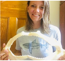 Amber Stevens holding a shark jaw